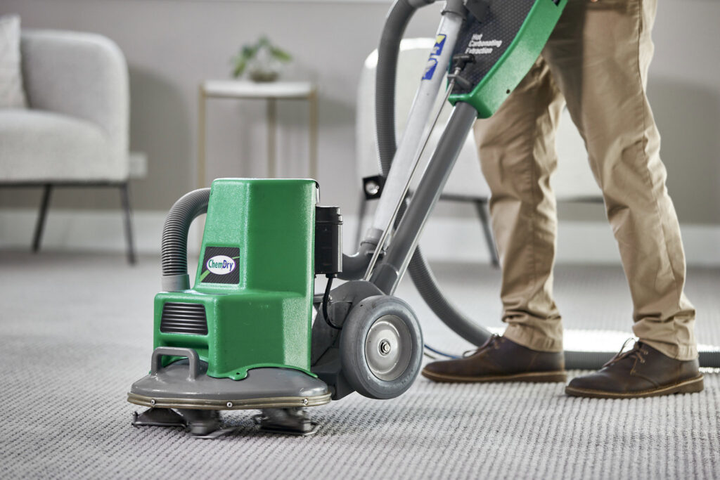 A Chem-Dry technician operating a carpet cleaning machine, providing professional service for ABC Chem-Dry St. Louis in St Charles, MO.
