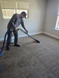 A carpet cleaning technician from CleanWater Restoration actively cleaning a residential carpet in Edmond, OK.