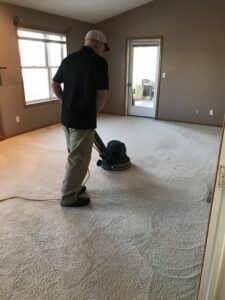 A Heaven's Best Carpet Cleaning technician operating a professional machine on a light-colored carpet in Fargo, ND.