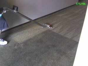A carpet cleaning technician operating a wand, showing a clean section of carpet by JP Carpet & Tile Care in Sherman Oaks, CA.