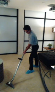 A carpet cleaning technician using a professional wand to clean a carpet at Oahu Carpet Cleaning Co. in Honolulu, HI.
