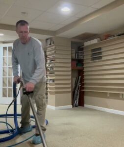 A carpet cleaning technician operating equipment on a residential carpet by On The Spot Carpet Cleaning in Erie, PA.