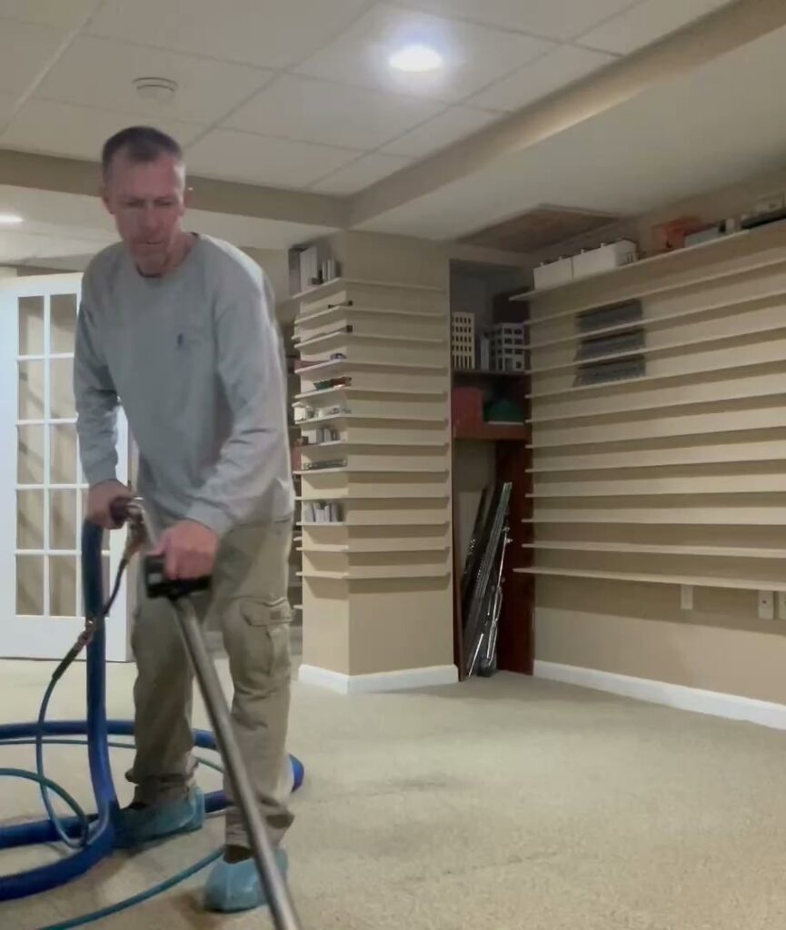 A carpet cleaning technician operating equipment on a residential carpet by On The Spot Carpet Cleaning in Erie, PA.