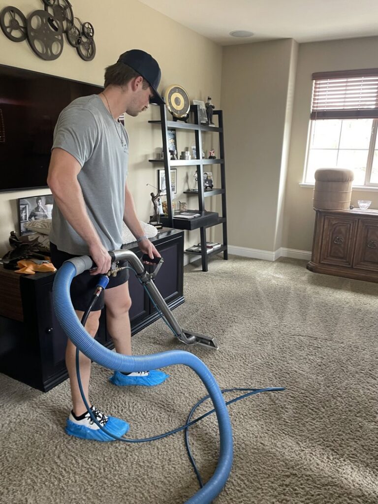 A Pro Team Carpet Cleaning Sacramento, CA technician wearing shoe covers while performing carpet cleaning.