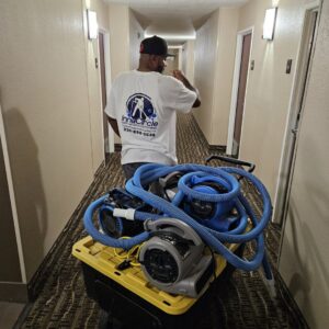 An InnaCircle technician with carpet cleaning equipment in a hallway in Greensboro, NC, ready for service.