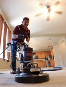A carpet cleaning technician operating a professional rotary machine for C&A Carpet Cleaning and Floor Solutions, LLC in San Antonio, TX.