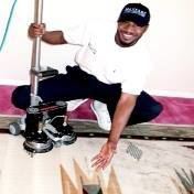 A carpet cleaning technician demonstrating the clean results on a patterned carpet for Maxcarp Carpet Cleaning in Kent, WA.