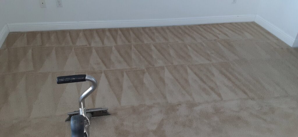A carpet cleaning tool in action, showing a clean path on a dirty carpet by M&M Carpet & Tile Care in Cape Coral, FL