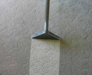 A carpet cleaning tool showing a clear before and after cleaning line on a light carpet by Hillsboro Carpet Cleaning in Hillsboro, OR.