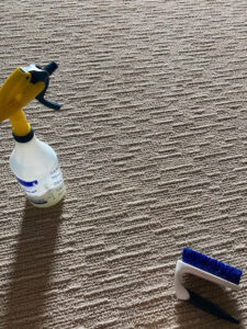 Carpet cleaning tools, including a spray bottle and a brush, ready for use by Heaven's Best Carpet Cleaning in Oklahoma City, OK.