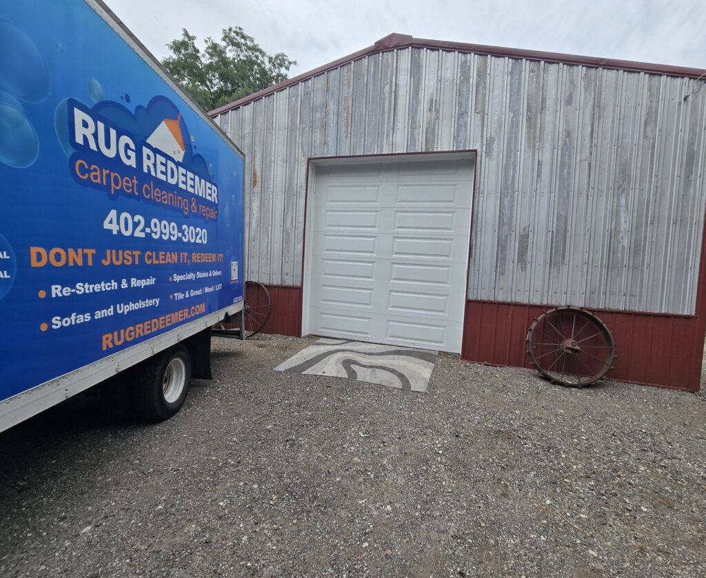 A Rug Redeemer carpet cleaning truck parked next to a commercial building for Inspection Ready LLC in Bellevue, NE.