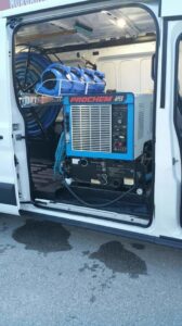 Interior of a work van showing professional truck-mount carpet cleaning equipment and hoses for Carpet Care in Reisterstown, MD.