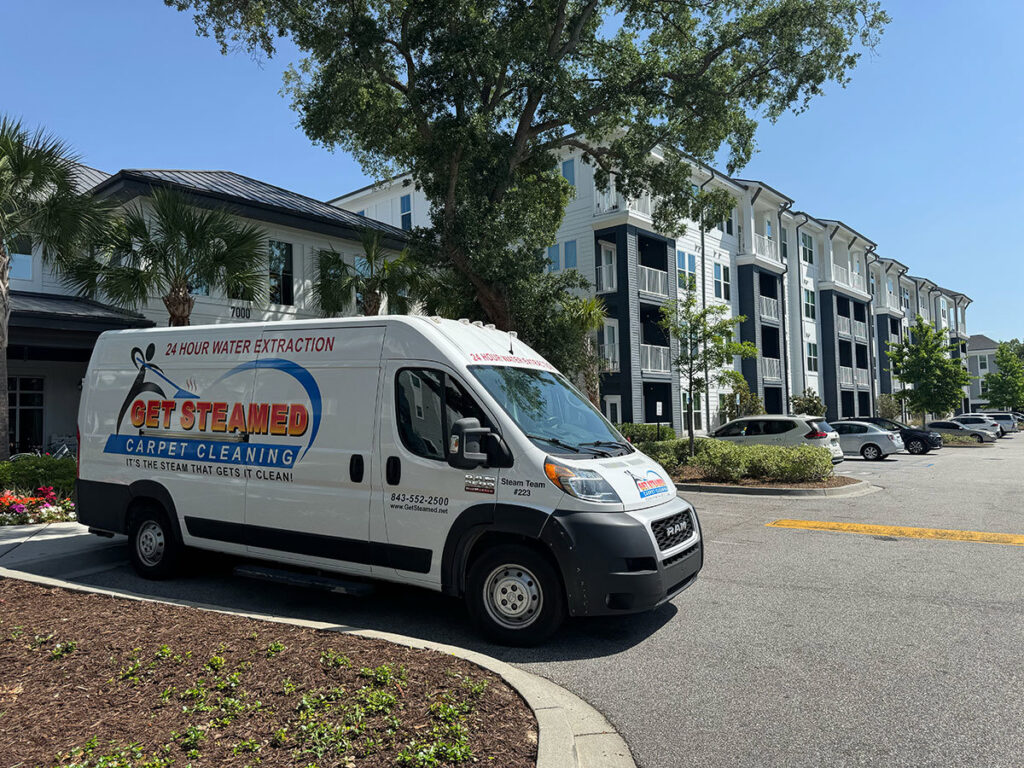 A Get Steamed Carpet Cleaning, Inc. van parked outside an apartment complex in North Charleston, SC.