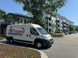 A Get Steamed Carpet Cleaning, Inc. van parked outside an apartment complex in North Charleston, SC.