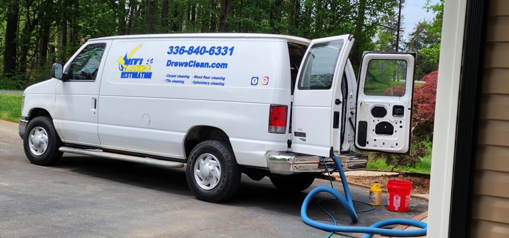 Drew's Cleaning and Restoration van with carpet cleaning equipment set up outside a home in Jamestown, NC.