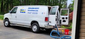 Drew's Cleaning and Restoration van with carpet cleaning equipment set up outside a home in Jamestown, NC.