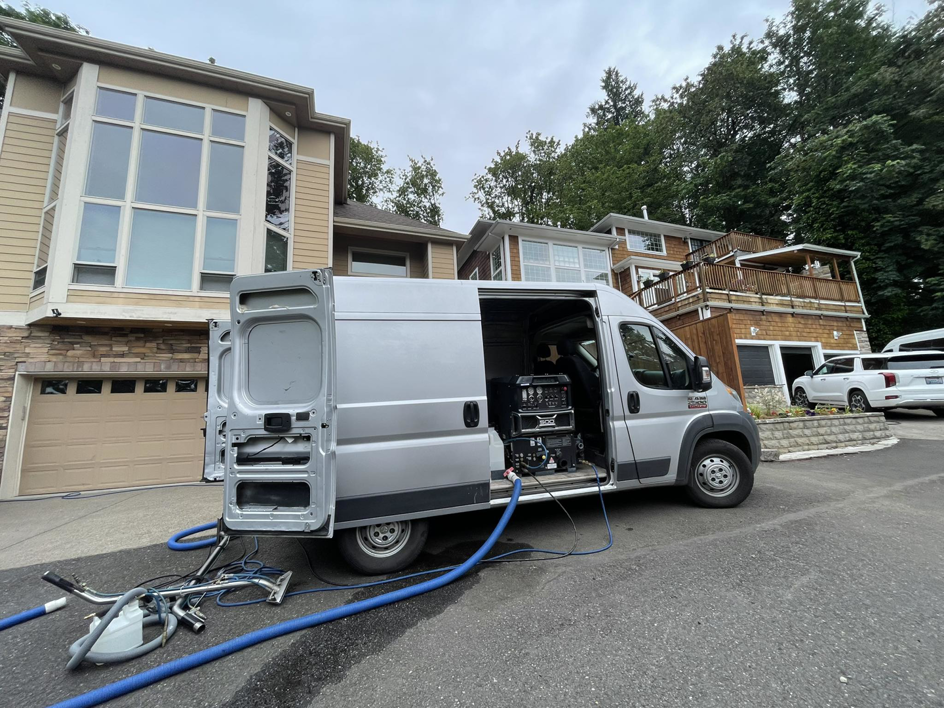 A carpet cleaning service van with hoses and equipment set up for a residential job by A&g's carpet cleaning service in Vancouver, WA.