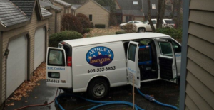 Arthur's Always Clean service van with hoses running into a building for a carpet cleaning job in Rochester, NH.
