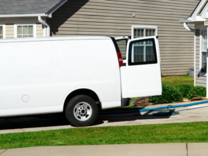 A white carpet cleaning van with hoses extended to a house, ready for service by East Valley Carpet Cleaners in Chandler, AZ