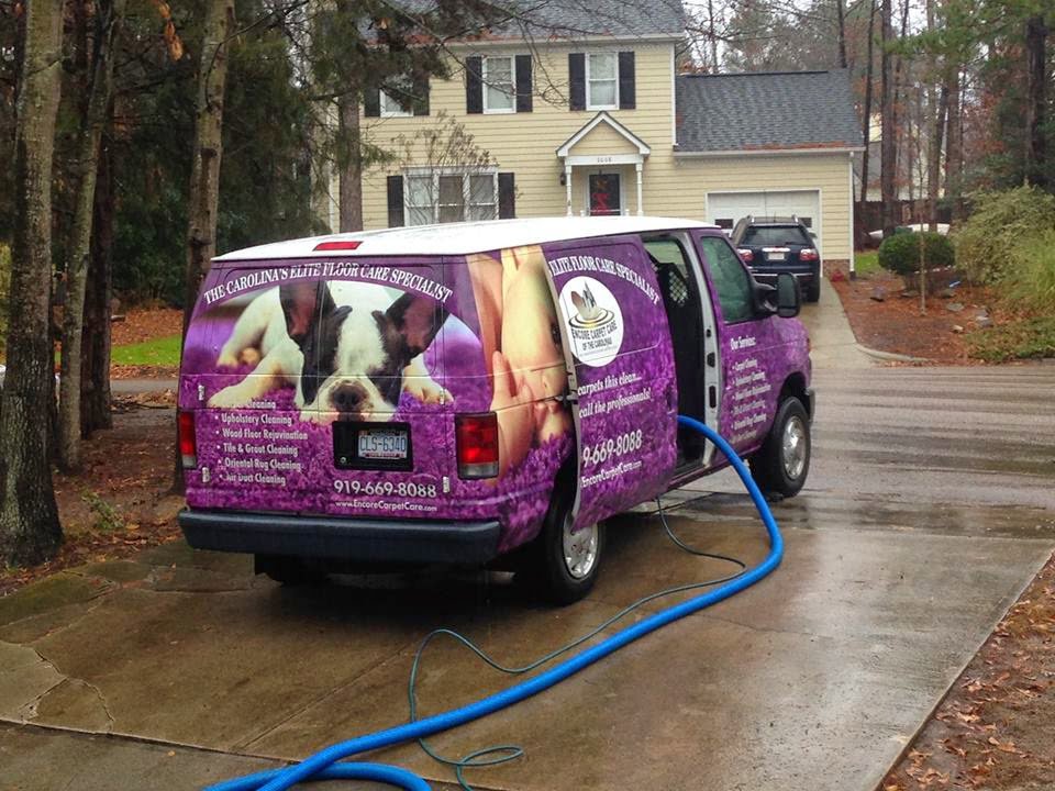 A branded Encore Carpet Care van with hoses running into a home for professional carpet cleaning in Fort Wayne, IN.