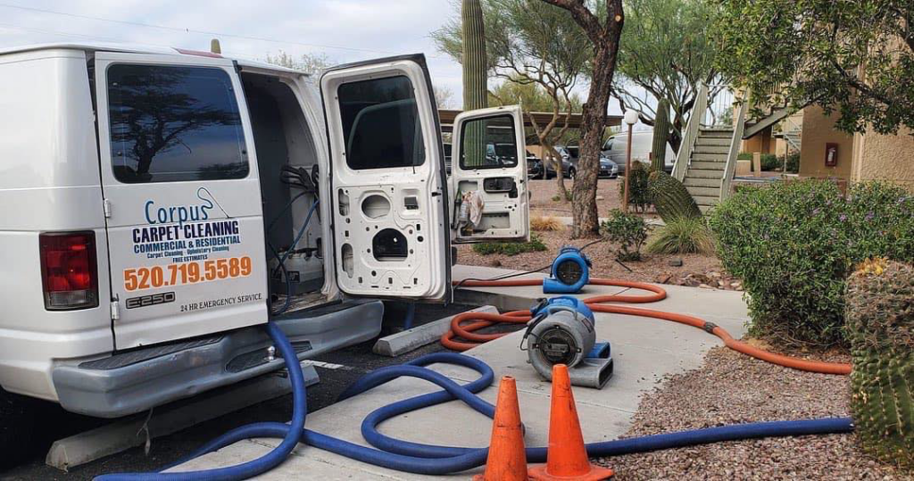 A Corpus Carpet Cleaning LLC van with hoses and fans set up for a carpet cleaning job in Tucson, AZ