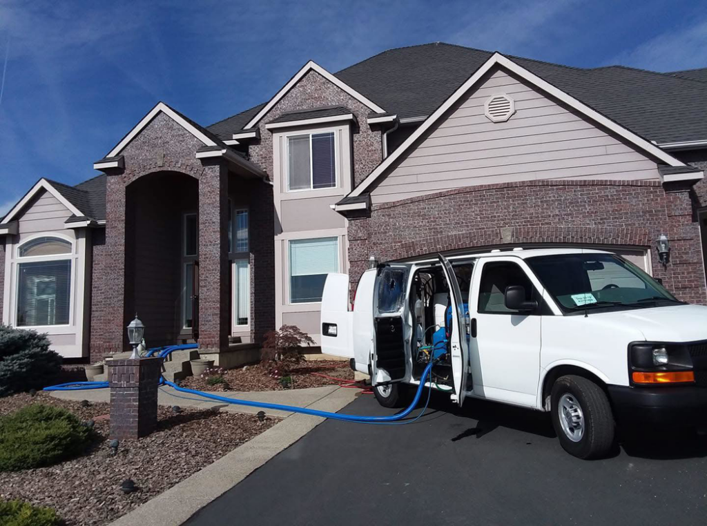 Professional carpet cleaning van with hoses extended into a home by JR Professional Carpet Cleaning Business LLC in Spokane, WA.