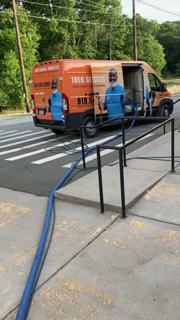 A Treo General Services of North Carolina LLC van with cleaning hoses extended for a job in Durham, NC.