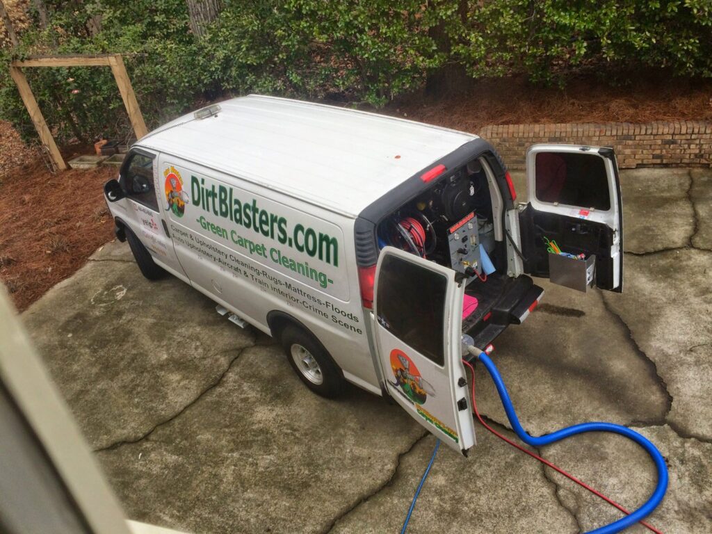 A Dirt Blasters Carpet Cleaning Inc. van parked with hoses running into a building for a job in Atlanta, GA