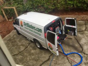 A Dirt Blasters Carpet Cleaning Inc. van parked with hoses running into a building for a job in Atlanta, GA
