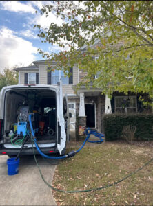 A professional carpet cleaning van parked outside a home with hoses extended, ready for service by Ype Cleaning LLC in Monroe, NC.