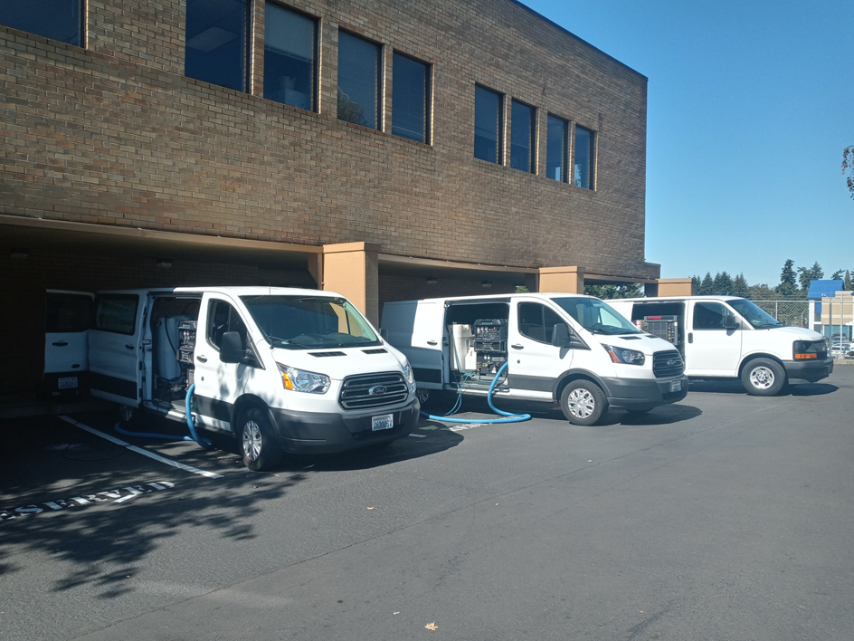 Carpet cleaning vans with visible equipment and hoses ready for service by Blue Rain Carpet Care LLC in Vancouver, WA.
