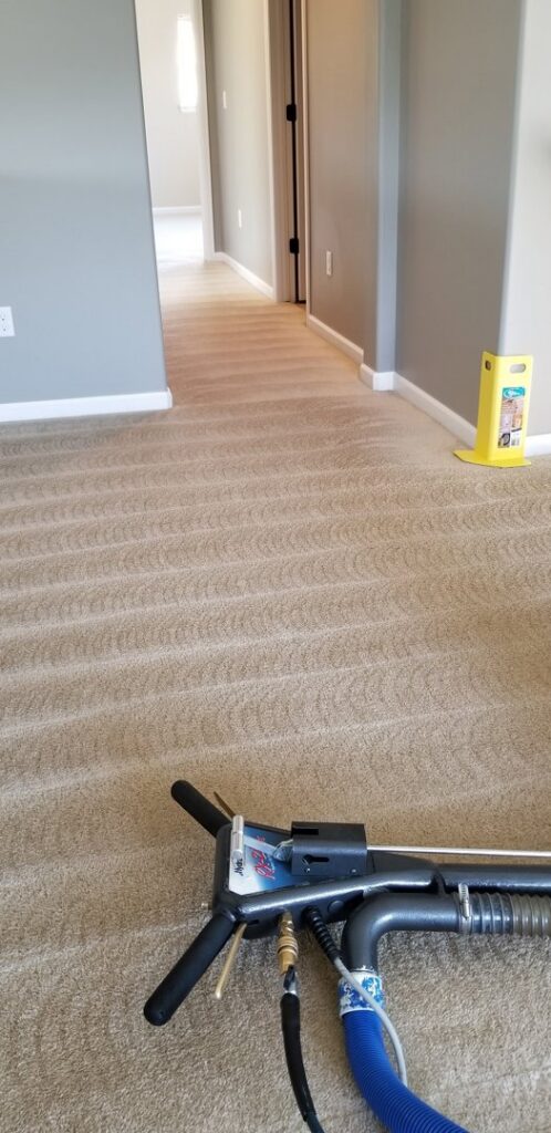 A carpet cleaning wand in action, leaving clean stripes in a hallway by Foothills Steam Carpet Cleaners in Fort Collins, CO.