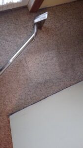 A professional carpet cleaning wand actively cleaning a carpet by Customer First Carpet Cleaning in Appleton, WI