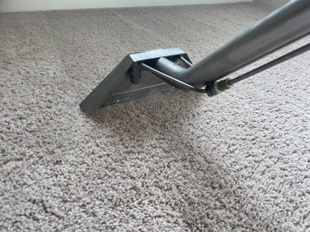 A professional carpet cleaning wand in action, deep cleaning a light-colored carpet by KANDE Carpet Cleaning in Pittsburgh, PA.