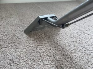 A professional carpet cleaning wand in action, deep cleaning a light-colored carpet by KANDE Carpet Cleaning in Pittsburgh, PA.
