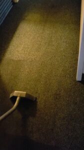 A carpet cleaning wand in action, cleaning a dark carpet by Superior Clean Carpet and Upholstery Care in Jacksonville, FL