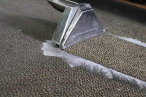 A close-up of a carpet cleaning wand in action, removing dirt from a carpet by Strategic Carpet Clean in Winter Park, Orlando, FL