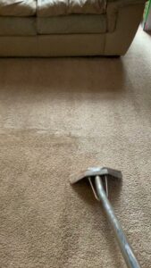 A carpet cleaning wand being used to clean a light brown carpet, showing effective cleaning by Superior Carpet Cleaning in Greenville, SC.