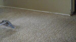 A professional carpet cleaning wand actively cleaning a light brown carpet by Tex A Clean Carpet Care in League City, TX.
