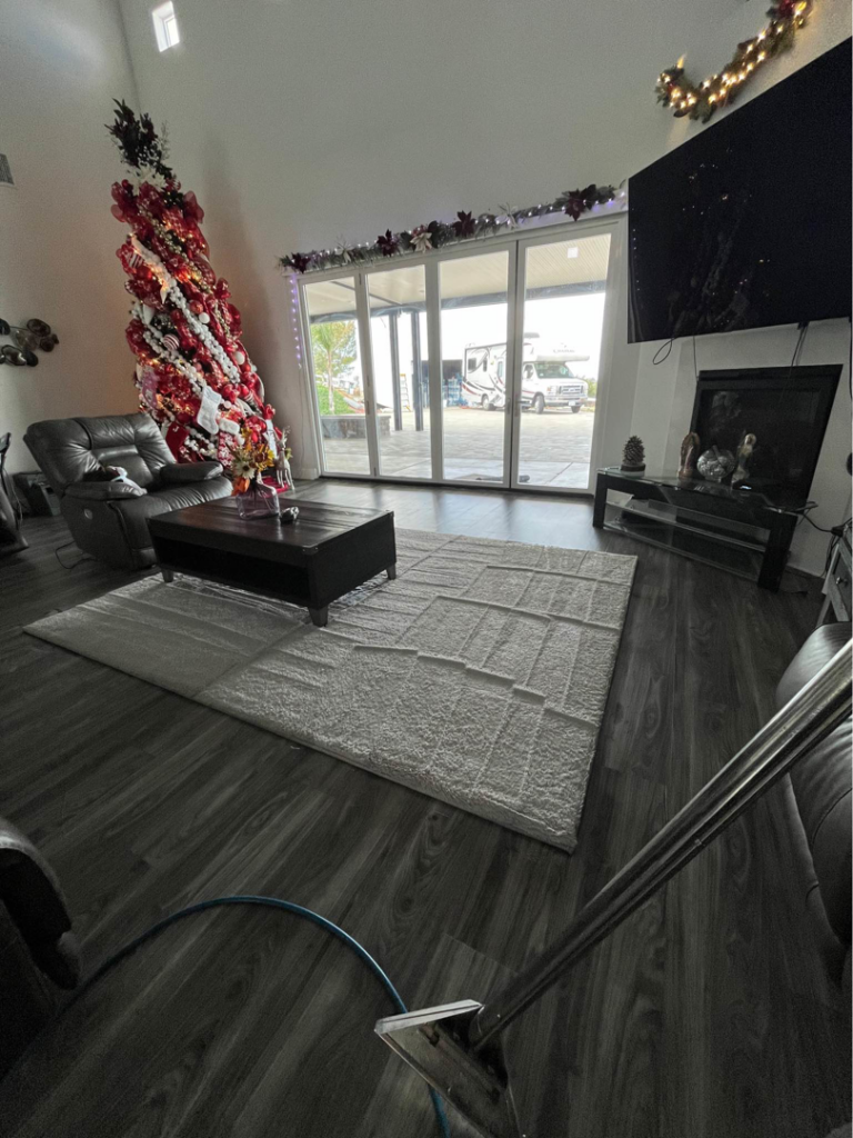 A carpet cleaning wand on an area rug in a living room, demonstrating services by Orozco's Janitorial Services LLC in Escondido, CA.