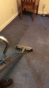 A professional carpet cleaning wand in action on a blue carpet by Monarch Cleaning Solutions in Parkville, MO
