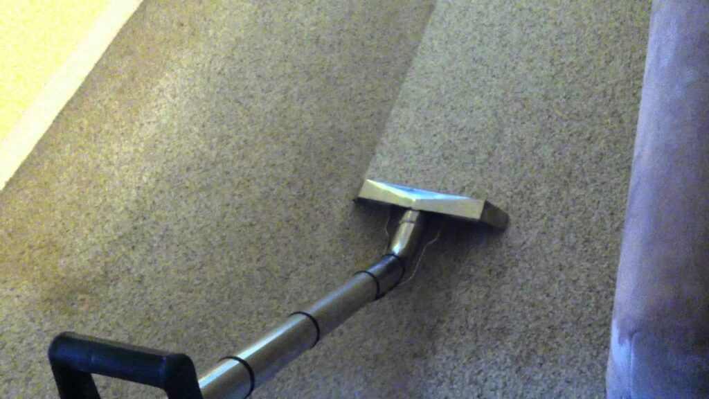 A carpet cleaning wand actively cleaning a carpet, leaving a visible clean path, by Steam Solutions Carpet Cleaning in San Antonio, TX.
