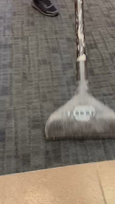 A carpet cleaning wand in action, cleaning a dark grey patterned carpet at Cosmo Carpet Cleaning in Princeton, NJ.