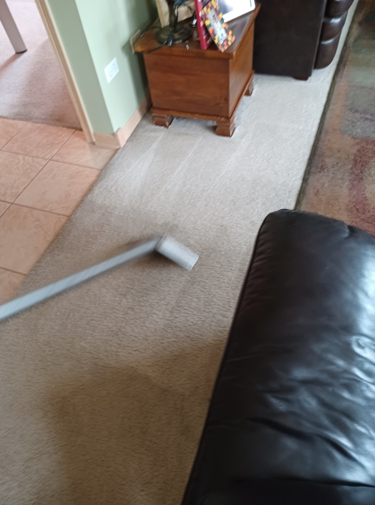 A carpet cleaning wand showing a distinct clean line on a residential carpet by Hopman Rug Cleaners in Hammond, IN.