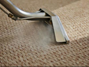 A close-up of a carpet cleaning wand steaming a light brown carpet by Xtreme Klene Carpet & Upholstery Cleaning in Montgomery, AL.