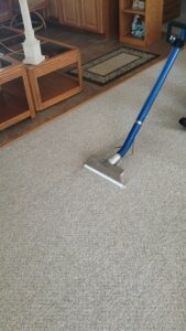 A professional technician using a carpet cleaning wand to deep clean a carpet for Carpet Care in Reisterstown, MD.