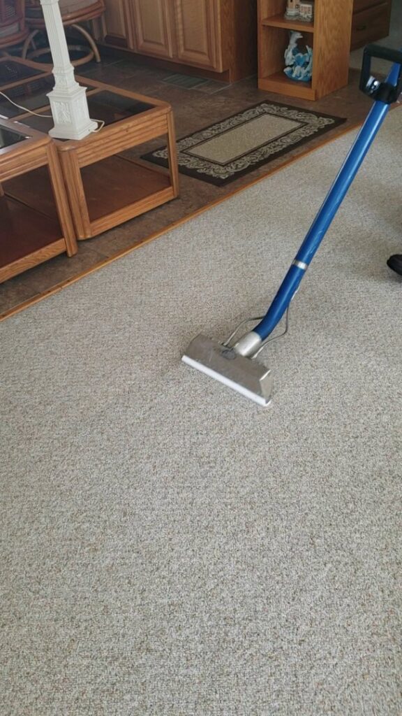 A professional technician using a carpet cleaning wand to deep clean a carpet for Carpet Care in Reisterstown, MD.