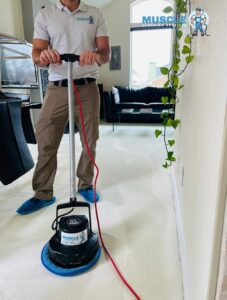 A professional from Muscle Cleaning Services cleaning a carpet with a rotary machine in Dallas, TX.