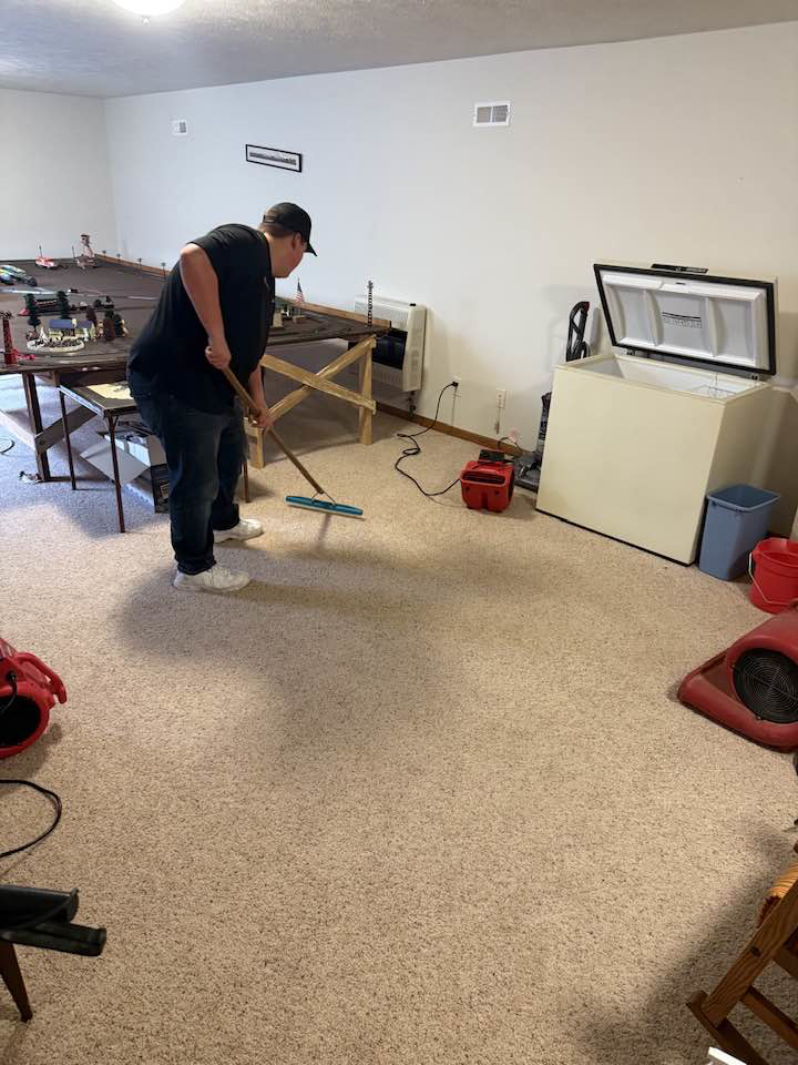 A professional from Sparkling clean using a squeegee tool to clean a large carpeted area in Salina, KS.
