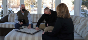 A carpet contractor from Carpets Direct Naperville, IL, showing carpet samples to clients during an in-home consultation.